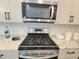 Stainless steel gas range oven with decorative accents on granite countertops and subway tile backsplash at 609 Sienna Way, Summerville, SC 29486