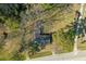 Bird's eye view of the property with its roof, surrounded by lush trees, and a glimpse of the adjacent road at 6156 Badham Dr, Reevesville, SC 29471