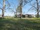 Spacious backyard featuring mature trees and a covered patio, perfect for outdoor living and entertaining at 6156 Badham Dr, Reevesville, SC 29471