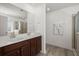 Bright bathroom featuring double sink vanity, large mirror and glass enclosed shower, along with wood-look floors at 686 Redbud Ln, Summerville, SC 29486