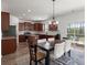 Well-lit kitchen with an island, wood cabinets, stainless steel appliances, granite countertops, and a dining area at 686 Redbud Ln, Summerville, SC 29486