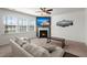 A well-lit living room featuring a fireplace, large windows, and neutral-toned furniture at 686 Redbud Ln, Summerville, SC 29486