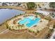 Aerial view of a community pool featuring a zero entry area, lap pool, and lounge areas with mature palms at 686 Redbud Ln, Summerville, SC 29486