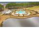 Overhead view of a community pool, showcasing lush landscaping, pool furniture, and nearby clubhouse at 686 Redbud Ln, Summerville, SC 29486