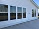 Backyard exterior showcasing a row of windows, white siding, and a concrete patio space at 752 Maynard Ln, Summerville, SC 29486