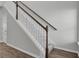 Staircase with white railings and gray carpet, transitioning to wood flooring on the lower level at 85 Arrowwood Way, Summerville, SC 29485