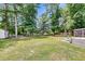 Expansive backyard featuring mature trees, a storage shed, and a relaxing hot tub area, perfect for outdoor living at 9360 S Moreto Cir, Summerville, SC 29485