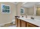 Bright bathroom with double sinks, wooden vanity, and tile flooring plus a window for natural light at 9360 S Moreto Cir, Summerville, SC 29485