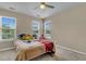 Bright bedroom features three sunny windows and neutral decor, enhanced by a ceiling fan at 9360 S Moreto Cir, Summerville, SC 29485