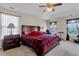Spacious bedroom features a tray ceiling, ceiling fan and three windows with window treatments at 9360 S Moreto Cir, Summerville, SC 29485