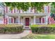 Inviting front porch featuring decorative columns, manicured shrubs, and a charming entryway with patriotic accents at 9360 S Moreto Cir, Summerville, SC 29485