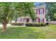 Inviting two-story home with a covered front porch, manicured lawn, and a vibrant American flag at 9360 S Moreto Cir, Summerville, SC 29485