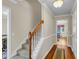 Hallway with hardwood floors, staircase, and elegant trim, leading to the dining area at 9360 S Moreto Cir, Summerville, SC 29485
