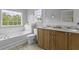 Bright bathroom featuring a garden tub, large window, and a double sink vanity at 9400 Divot Ln, Summerville, SC 29485