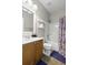 Well-lit bathroom with a single vanity, bathtub with shower, and floral shower curtain offering essential amenities at 9400 Divot Ln, Summerville, SC 29485