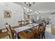 Open-concept dining area with wood floors, large table, and seamless transition to the living room at 9400 Divot Ln, Summerville, SC 29485