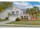 Charming two-story home featuring a manicured lawn, palm trees and an attached two-car garage at 9400 Divot Ln, Summerville, SC 29485