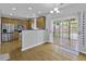 Bright kitchen area boasts hardwood floors, stainless appliances, and sliding glass doors to the screened in porch at 9400 Divot Ln, Summerville, SC 29485