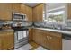 Kitchen with stainless steel appliances, wood cabinets, tile backsplash, and hardwood floors at 9400 Divot Ln, Summerville, SC 29485