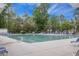Large community pool with plenty of lounge chairs around the pool deck in a fenced-in area with mature trees around at 9684 Pebble Creek Blvd, Summerville, SC 29485