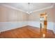 Formal dining room with wainscoting, hardwood floors, and chandelier, perfect for entertaining guests at 9684 Pebble Creek Blvd, Summerville, SC 29485