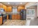 Modern kitchen with stainless steel appliances, wooden cabinets, and tile flooring, perfect for culinary enthusiasts at 9684 Pebble Creek Blvd, Summerville, SC 29485