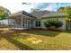 Backyard featuring a screened porch on a home with beige siding and a well-maintained lawn at 102 Kapalua Run, Summerville, SC 29483