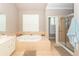Large primary bathroom features a soaking tub, walk-in shower, and shuttered window at 1021 Barfield St, Charleston, SC 29492