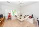Living room with a white sectional couch, ceiling fan, and plantation shutters at 1021 Barfield St, Charleston, SC 29492