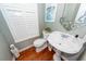 Half bathroom with wood flooring, pedestal sink, decorative mirror and window shutters at 1021 Barfield St, Charleston, SC 29492