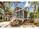 Exterior view of a charming screened-in porch with white railings and a lush, landscaped yard at 1021 Barfield St, Charleston, SC 29492