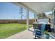 Backyard featuring a hot tub, green grass, and blue rocking chairs on a concrete porch at 106 Wood Sage Run, Summerville, SC 29485