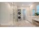 Bright bathroom showcasing a tiled shower, laundry area, vanity, and ample counter space at 106 Wood Sage Run, Summerville, SC 29485