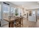 Eat-in kitchen features dining space with wood table, island, and white cabinetry with stainless steel appliances at 106 Wood Sage Run, Summerville, SC 29485