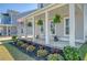 Inviting front porch with hanging plants, rocking chairs, and colorful flower arrangements, perfect for relaxing at 106 Wood Sage Run, Summerville, SC 29485