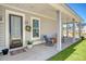 Cozy front porch featuring a classic rocking chair, a charming wreath, and a welcoming entrance at 106 Wood Sage Run, Summerville, SC 29485