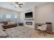 Bright living room with a cozy fireplace, large leather couch, and a stylish desk area, perfect for relaxation at 106 Wood Sage Run, Summerville, SC 29485