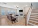 Comfortable living room featuring a modern fireplace, hardwood floors, and staircase access to the upper level at 106 Wood Sage Run, Summerville, SC 29485