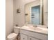 Powder room featuring a white vanity, toilet, mirror, and neutral wall color at 106 Wood Sage Run, Summerville, SC 29485