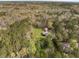 Aerial view of a home and outbuilding surrounded by a lush forest with vibrant trees and an expansive lawn at 117 Wernham Ln, Moncks Corner, SC 29461