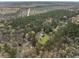 Wide aerial shot showcasing a property with a house and metal building nestled within a vast forest at 117 Wernham Ln, Moncks Corner, SC 29461