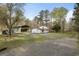 Exterior of home with a barn, surrounded by trees and gravel driveway at 117 Wernham Ln, Moncks Corner, SC 29461