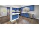 Bright kitchen with stainless appliances, blue cabinets, an island, and wood-look floors at 117 Wernham Ln, Moncks Corner, SC 29461