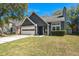 Charming exterior featuring a two-car garage, well-maintained lawn, and classic design under a clear blue sky at 125 Mansfield Blvd, North Charleston, SC 29418