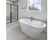 Bathroom with a standalone tub, a frameless glass shower, and large window at 136 Mitch Ln, Holly Hill, SC 29059