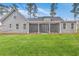 Spacious screened porch at the rear of a home with gray vinyl siding surrounded by a lush green lawn at 136 Mitch Ln, Holly Hill, SC 29059