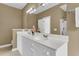 Bathroom featuring a double vanity with white cabinets, beige walls, and large mirror at 1362 Kingsford Ln, Mount Pleasant, SC 29466
