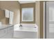 Bright bathroom showcasing a soaking tub with white cabinets and beige walls at 1362 Kingsford Ln, Mount Pleasant, SC 29466