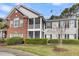 Charming multi-story townhouse with a screened porch, brick facade, and neatly manicured hedges at 1362 Kingsford Ln, Mount Pleasant, SC 29466