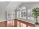 Bright living room with hardwood floors, vaulted ceilings, and plantation shutters, enhanced by a stylish ceiling fan at 1362 Kingsford Ln, Mount Pleasant, SC 29466